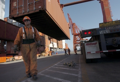 Workers unload a container vessel docked in Ensenada, Mexico.