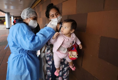 A nurse takes the temperature of a baby in Colombia. (AP)