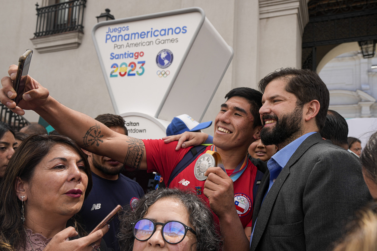 A young supporter takes a selfie with Chilean President Gabriel Boric. (AP)