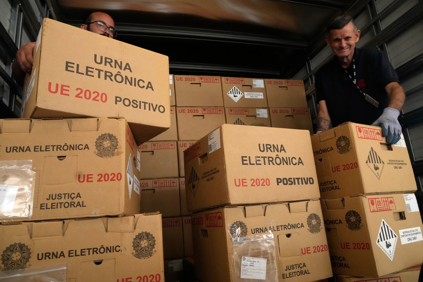  (Caption: Electoral workers load sealed electronic voting machines in Brasília for the 2026 general election.)
