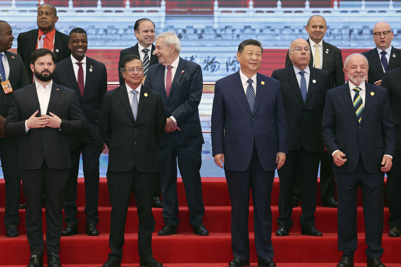 (L-R) Presidents Gabriel Boric (Chile), Gustavo Petro (Colombia), Xi Jinping (China), and Luiz Ignacio Lula da Silva (Brazil) stand on a raised stage with other CELAC leaders.