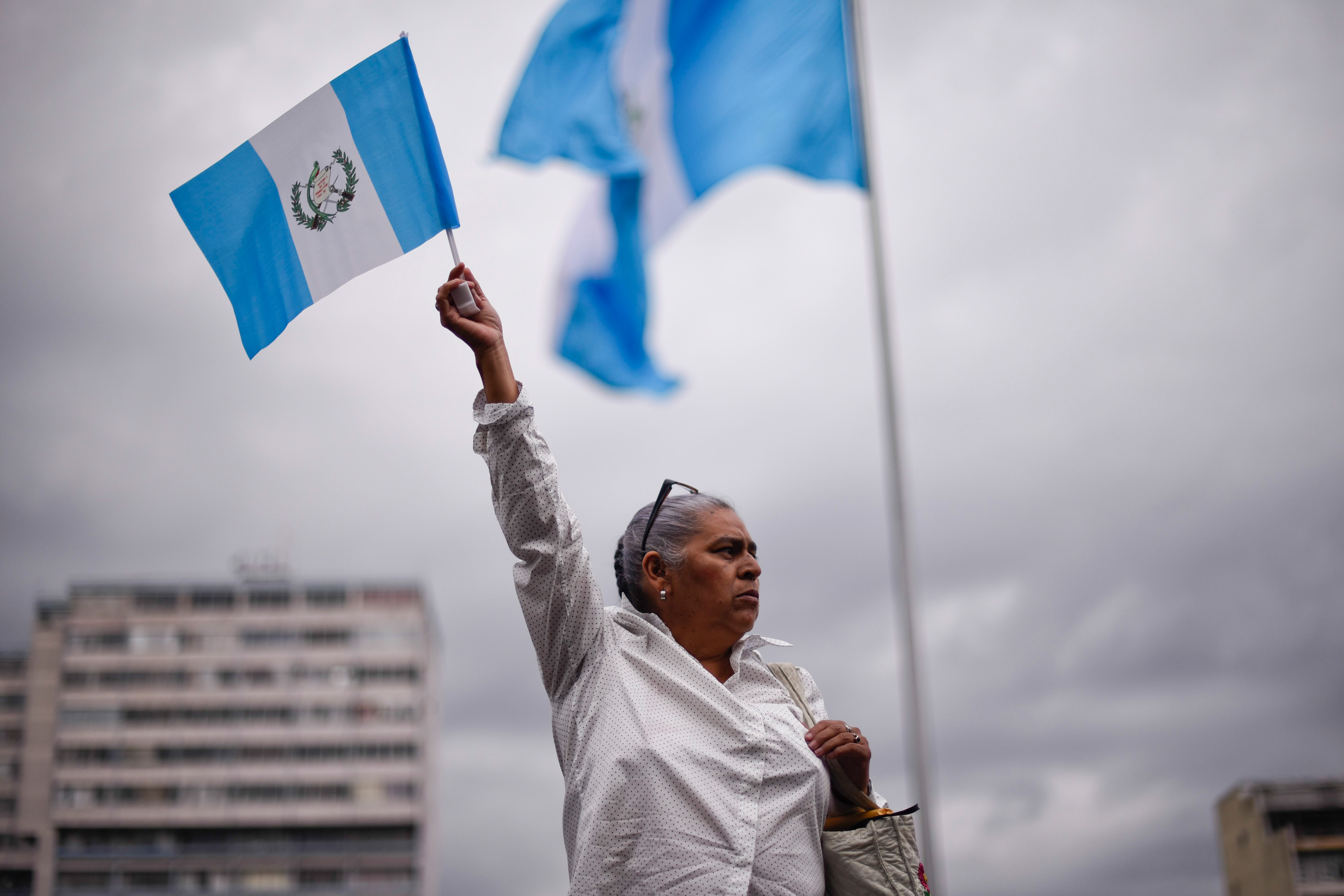 A woman holds up a Guatemala national flag. (AP)