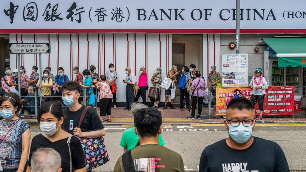Pedestrians cross the street in front of the Chinese state-owned commercial banking company Bank of China branch in Hong Kong. (AP)