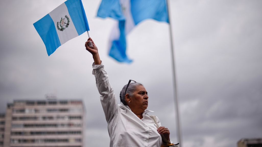 A woman holds up a Guatemala national flag. (AP)