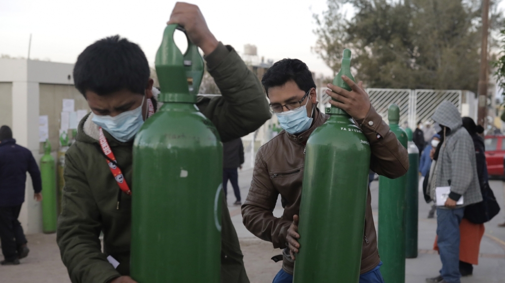 Peruvians carry oxygen tanks. (AP)