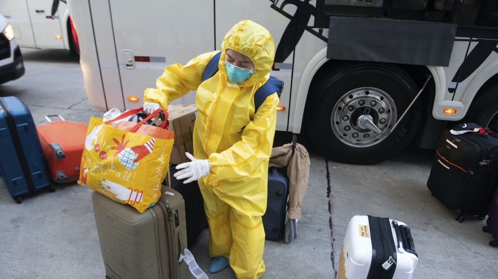 A cruise ship crew worker in a protective mask and full body suit checks into a hotel in Uruguay. (AP)