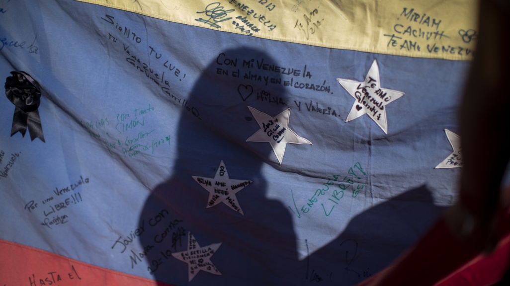 Silhouette on a Venezuelan flag at a voting center in Madrid, Spain. (AP)