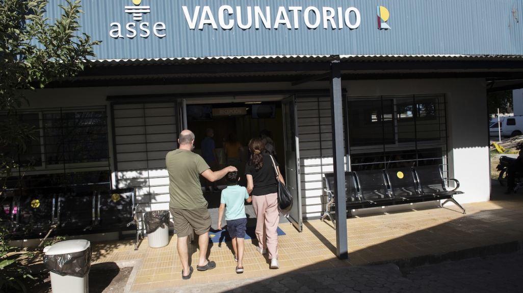 Una pareja lleva a su hijo a vacunarse contra el COVID-19 en Uruguay. 