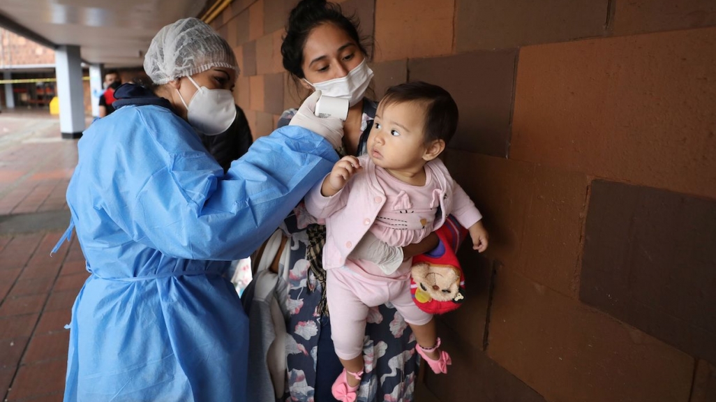 A nurse takes the temperature of a baby in Colombia. (AP)