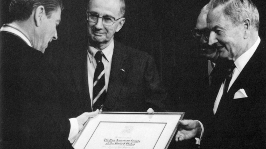 U.S. President Ronald Reagan (L), receiving the 1987 Gold Insigne from AS/COA President Emeritus George W. Landau and David Rockefeller.