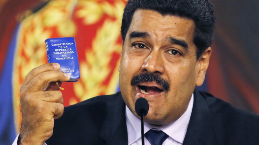 Nicolas Maduro holding a tiny constitution