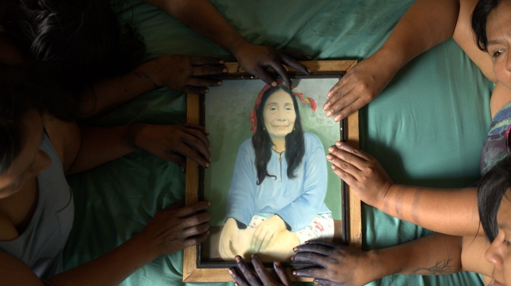 Multiple people holding a frame