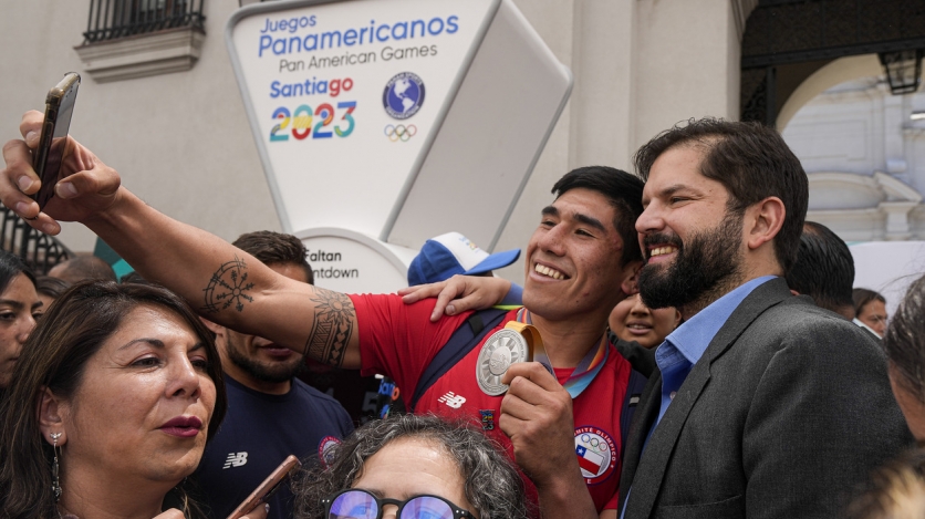 A young supporter takes a selfie with Chilean President Gabriel Boric. (AP)