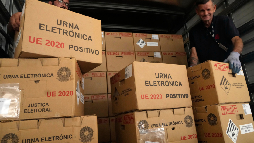  (Caption: Electoral workers load sealed electronic voting machines in Brasília for the 2026 general election.)