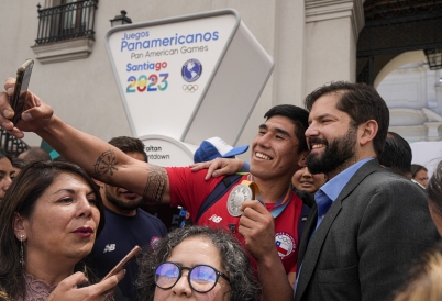 A young supporter takes a selfie with Chilean President Gabriel Boric. (AP)