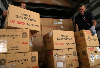  (Caption: Electoral workers load sealed electronic voting machines in Brasília for the 2026 general election.)