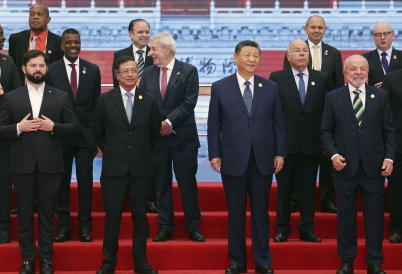 (L-R) Presidents Gabriel Boric (Chile), Gustavo Petro (Colombia), Xi Jinping (China), and Luiz Ignacio Lula da Silva (Brazil) stand on a raised stage with other CELAC leaders.