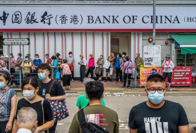 Pedestrians cross the street in front of the Chinese state-owned commercial banking company Bank of China branch in Hong Kong. (AP)