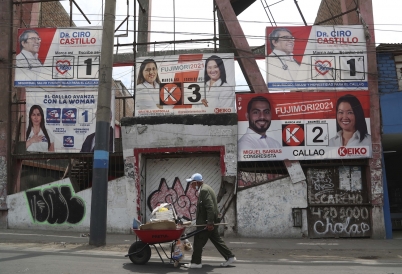 A man walks by campaign posters in Lima. (AP)