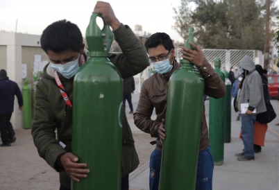 Peruvians carry oxygen tanks. (AP)