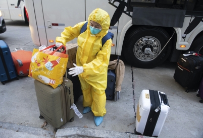 A cruise ship crew worker in a protective mask and full body suit checks into a hotel in Uruguay. (AP)