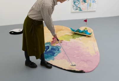 Picture of a mini golf installation and a woman playing 