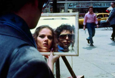 Photo of the mirror reflection of a man and a woman on a street