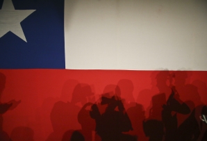 Silhouettes against the Chilean flag. (AP)