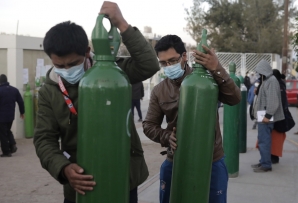 Peruvians carry oxygen tanks. (AP)