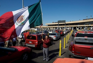 A man waves a flag at the Tijuana-San Diego border crossing.